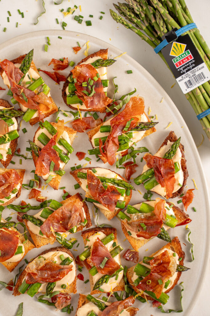 Mini toasts with asparagus with on a platter.